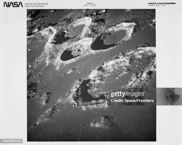 Craters on the lunar surface in an image taken using long-focal length lens, showing the large crater Goclenius, alongside three clustered craters in...