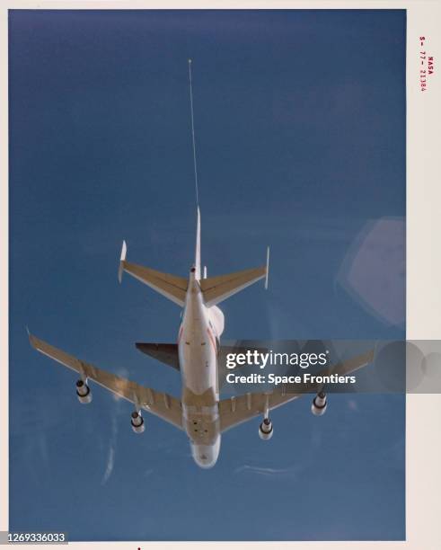 Underside view of the Space Shuttle Enterprise riding piggyback atop NASA 905, a 747 carrier aircraft, during the first of six Approach and Landing...