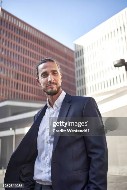 confident businessman standing in city - veste homme photos et images de collection