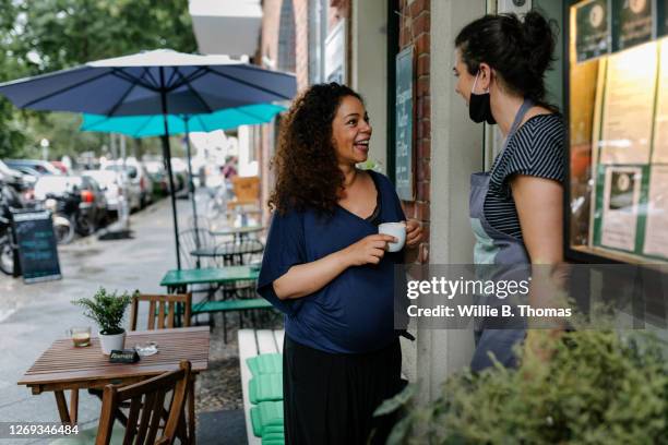 pregnant woman talking to restaurant owner - pregnant coffee 個照片及圖片檔