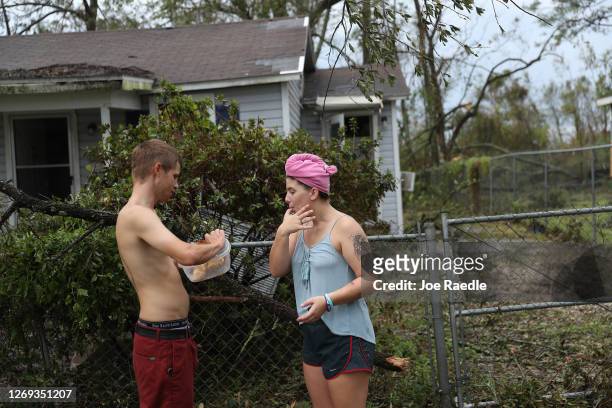 Trey Korn and Danielle May enjoy chicken that their neighbor barbecued for them since the neighborhood has no electrical power after Hurricane Laura...