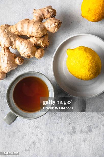 studio shot of cup of tea,lemons and ginger root - ginger tea stock pictures, royalty-free photos & images