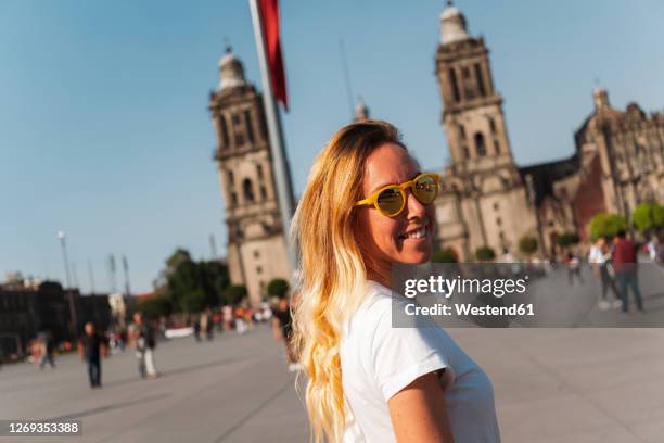 smiling young woman wearing sunglasses while standing at zocalo square, mexico - mexico city imagens e fotografias de stock