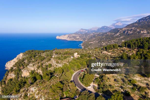 spain, mallorca, deia, drone view of coastal highway and surrounding landscape of serra de tramuntana - sierra de tramuntana stock pictures, royalty-free photos & images