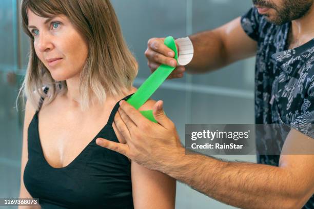 shoulder treatment with kinesio tape - kinesiotape stock pictures, royalty-free photos & images