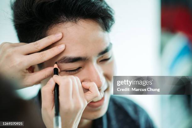 aziatisch chinees mannetje dat wenkbrauw het waxen bij gezichtsschoonheidssalon krijgt - eyebrow pencil stockfoto's en -beelden