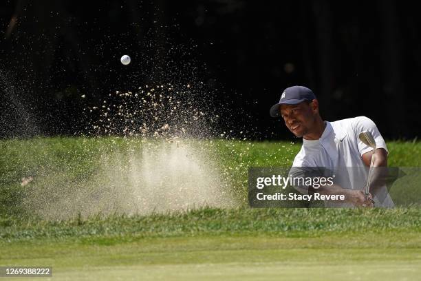 Tiger Woods of the United States plays a shot from a bunker on the first hole during the second round of the BMW Championship on the North Course at...