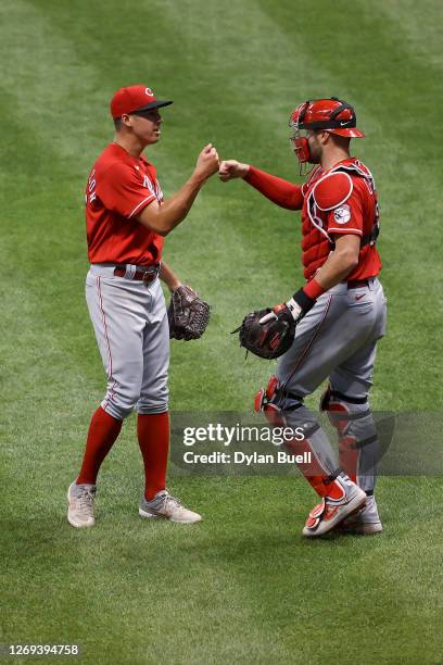 Robert Stephenson and Curt Casali of the Cincinnati Reds celebrate after beating the Milwaukee Brewers 6-1 during game one of a doubleheader at...