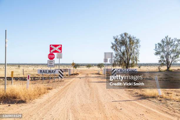dirt road going through a railway crossing in the dry, drought area of australia - sinais de cruzamento - fotografias e filmes do acervo