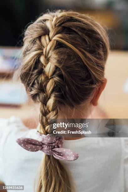 girl with a beautiful hairstyle: a braid - braiding plaits stock pictures, royalty-free photos & images