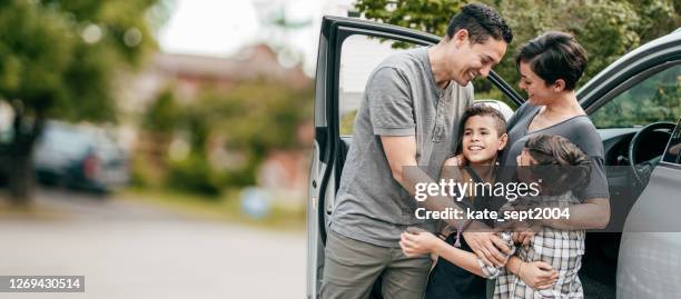 familia con dos hijos. momento con abrazos cerca del coche - car insurance fotografías e imágenes de stock