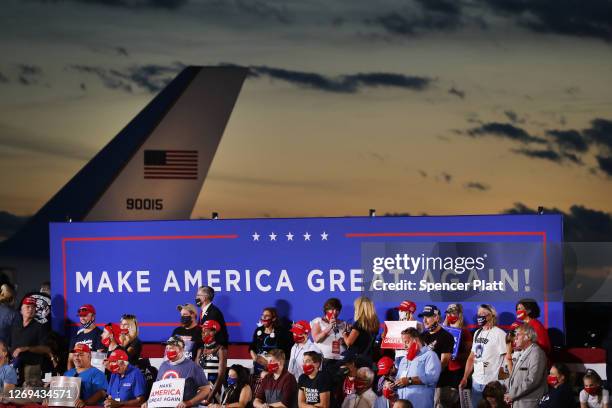 Supporters of President Donald Trump listen as he speaks at an airport hanger at a rally a day after he formally accepted his party’s nomination at...