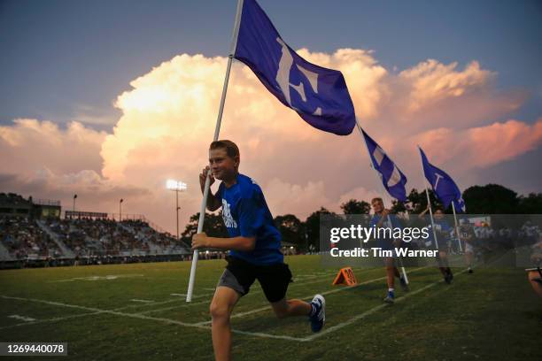 Band members of the Edna Cowboys carry flags after a touchdown in the first half against the East Bernard Brahmas on August 28, 2020 in East Bernard,...
