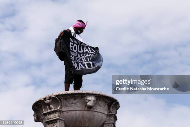 An activist waves a flag in support of Black Lives Matter atop the Lincoln Memorial during the Commitment March on August 28, 2020 in Washington, DC....