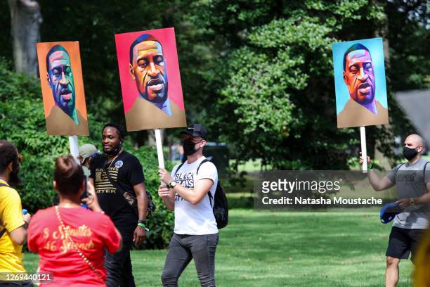 Protesters hold signs of George Floyd during the Commitment March at the Lincoln Memorial on August 28, 2020 in Washington, DC. Rev. Al Sharpton and...