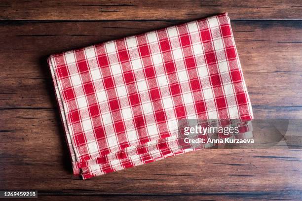 checkered red napkin on an old wooden brown background, top view. image with copy space. kitchen table with a towel - top view with copy space. - napkin stock pictures, royalty-free photos & images
