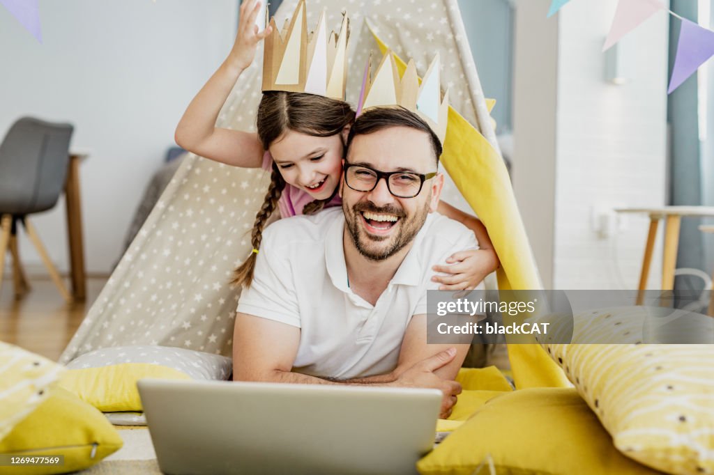 Pai e filha usando laptop em casa