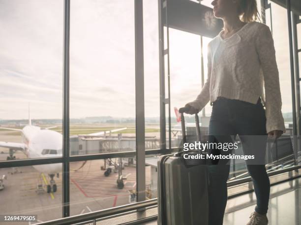 woman with hand luggage walking in airport - zurich airport stock pictures, royalty-free photos & images