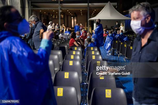 People wearing protective masks checke for their assigned seat before the live performance of Marc Ducret Metatonal at Torino Jazz Festival on August...