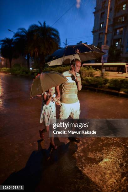 grandfather and granddaughter walking in the heavy rain - light rainfall in mumbai stock pictures, royalty-free photos & images