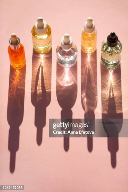 row of bottles with lotions - essential oil stock-fotos und bilder