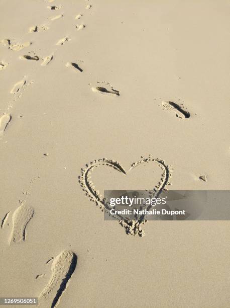 heart drawn on the sand and footprints on the beach - footprint heart shape stock pictures, royalty-free photos & images