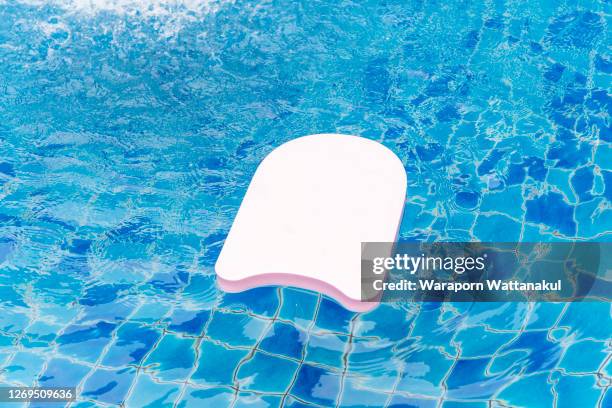 floating foam on blue swimming pool - pull foto e immagini stock