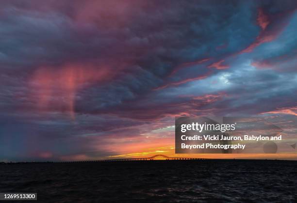 pink puffy clouds, blue sky and robert moses bridge at babylon, long island - robert moses bridge stockfoto's en -beelden