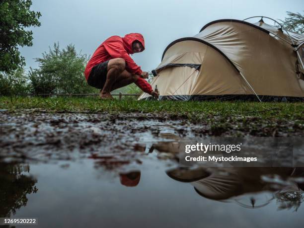 man fångad i en regnstorm medan camping - camping rain bildbanksfoton och bilder