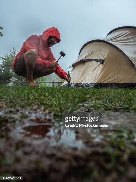 man caught in a rainstorm while camping - mid adult stock pictures, royalty-free photos & images