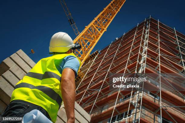 construction engineer supervising building process - scaffolding workers stock pictures, royalty-free photos & images