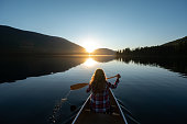 Woman canoeing on a stunning mountain lake