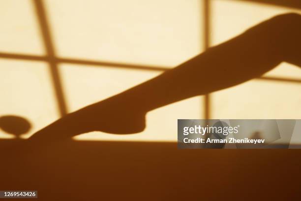 shadow of a woman's leg playing footsie with an object - playing footsie 個照片及圖片檔