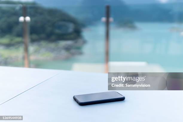 close-up of smart phone on the table at balcony - table only close up stock-fotos und bilder