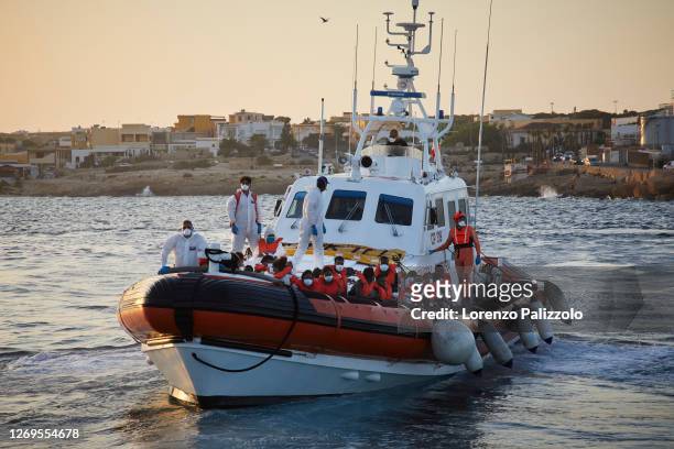 An Italian Coast Guard boat gets ready to dock in the port before disembarking a group of migrants from Libya that were rescued near the coast of...