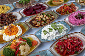 Traditional Turkish and Greek dinner meze table. Turkish Cuisine Cold Appetizers (appetizers with olive oil). Turkish appetizers in colorful plates. yogurt and various boiled herbs.