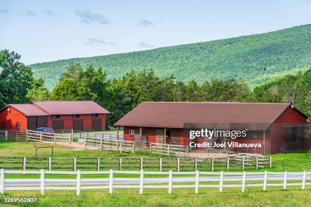 scenic red barn surrounded by mountains in upstate new york. - agrarisch gebouw stockfoto's en -beelden