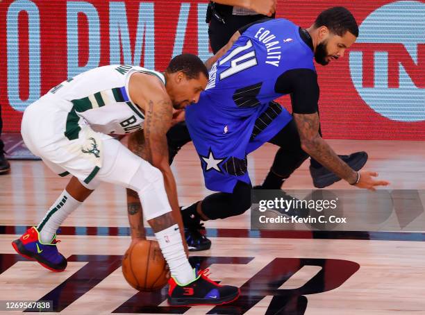 George Hill of the Milwaukee Bucks saves a loose ball against D.J. Augustin of the Orlando Magic during the third quarter in Game Five of the Eastern...