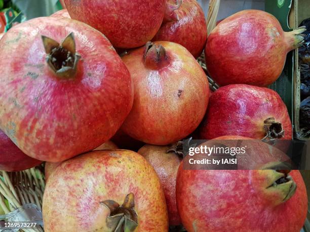 big, ripe pomegranates at the market - rosh hashanah stock pictures, royalty-free photos & images