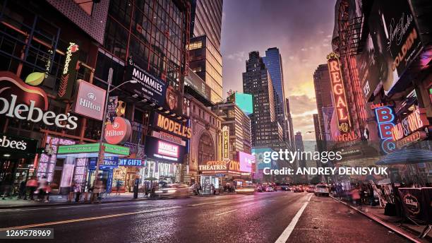 grand shine of 42nd street. new york. classical view of times square. illuminated advertisement billboards. dramatic sunset. - new york city exteriors and landmarks stockfoto's en -beelden