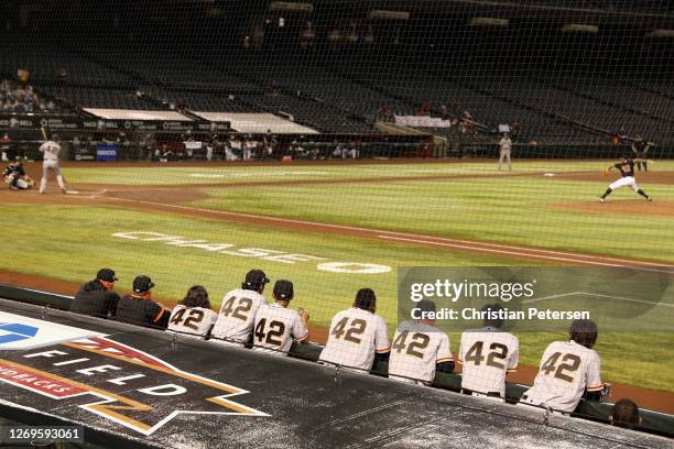 Members of the San Francisco Giants stand against the dugout railing all wearing during the sixth inning of the MLB game against the Arizona...