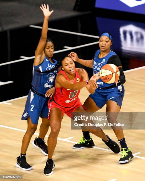 Betnijah Laney of the Atlanta Dream looks to pass the ball as Crystal Dangerfield and Odyssey Sims of the Minnesota Lynx defend during the first half...