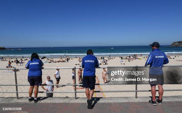 Three local council rangers talk to beachgoers at Bondi Beach on August 30, 2020 in Sydney, Australia. Warm winter weather is being enjoyed across...