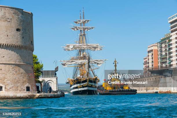 the italian navy sail ship "amerigo vespucci" moored to the aragonese castle's dock in  taranto, italy; - amerigo vespucci nave stock pictures, royalty-free photos & images