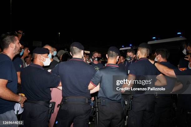 Some inhabitants of the island of Lampedusa protest in front of the port entrance against police to prevent the disembarkation of migrants on August...