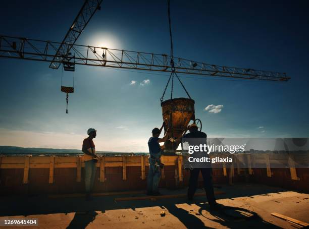 construction workers finishing rooftop wall on the apartment building. - radio controlled handset stock pictures, royalty-free photos & images