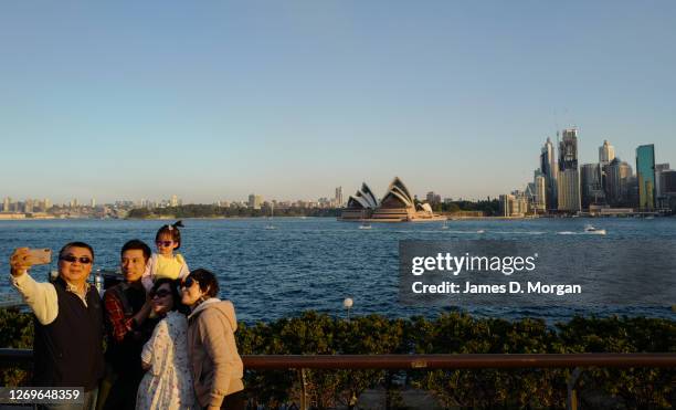 Family take a selfie on their mobile phone during the sunset in the suburb of Kiribilli on August 30, 2020 in Sydney, Australia. Warm winter weather...