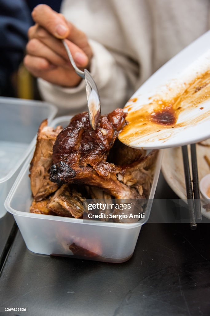 Chinese roast duck into a takeout container
