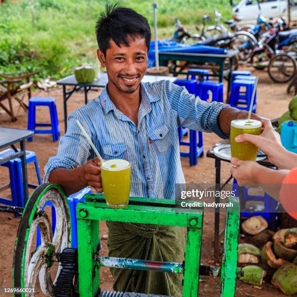 young burmese man making a sugar cane juice in bagan, myanmar - burmese people stock pictures, royalty-free photos & images
