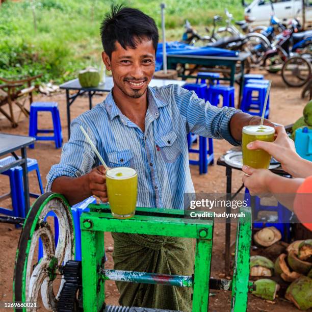 young burmese man making a sugar cane juice in bagan, myanmar - myanmar food stock pictures, royalty-free photos & images